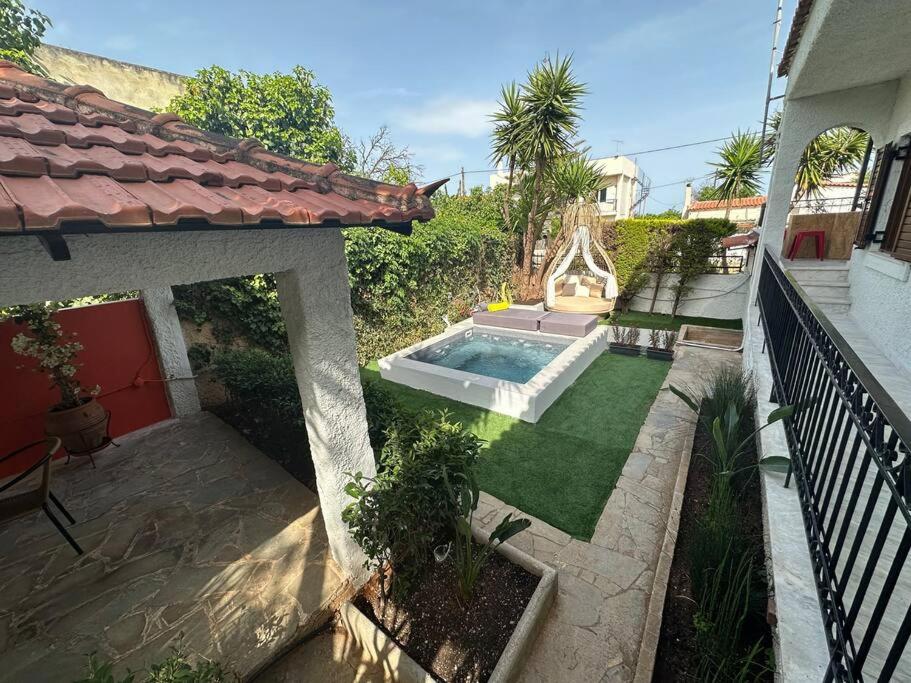 a backyard with a swimming pool and a house at Caja De Anthea in Artemida