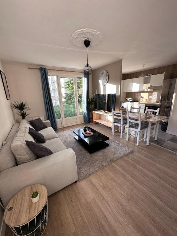 uma sala de estar com um sofá e uma mesa em Apparemment T3 55m2 em Lourdes