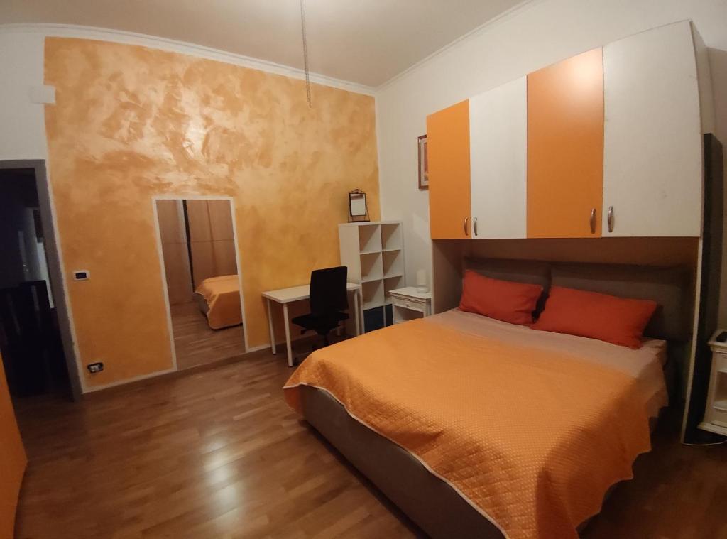 a bedroom with a bed with orange sheets and orange pillows at Sweet Home Bari in Bari