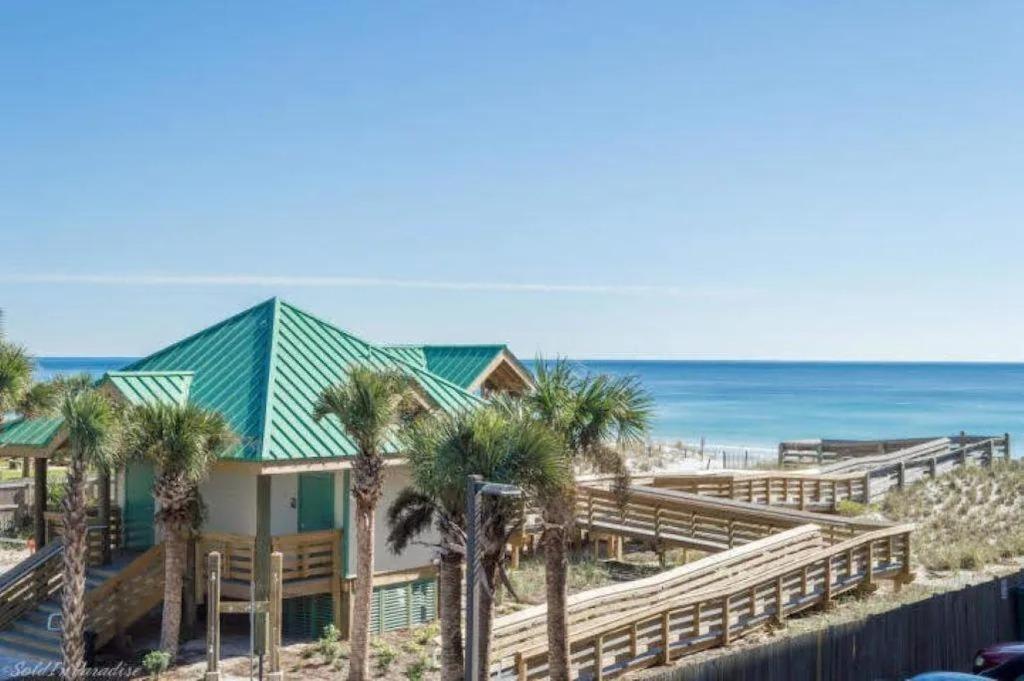 a house on the beach with palm trees and the ocean at Nautilus 2310 Gulf View 2 Bedroom 3rd Floor Free Beach Service in Fort Walton Beach