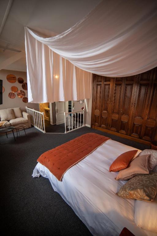 a bedroom with a large bed with a canopy at MAISON RENARD in Béthune