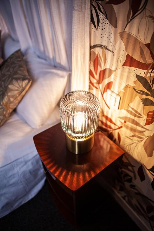 a lamp on a table next to a bed at MAISON RENARD in Béthune
