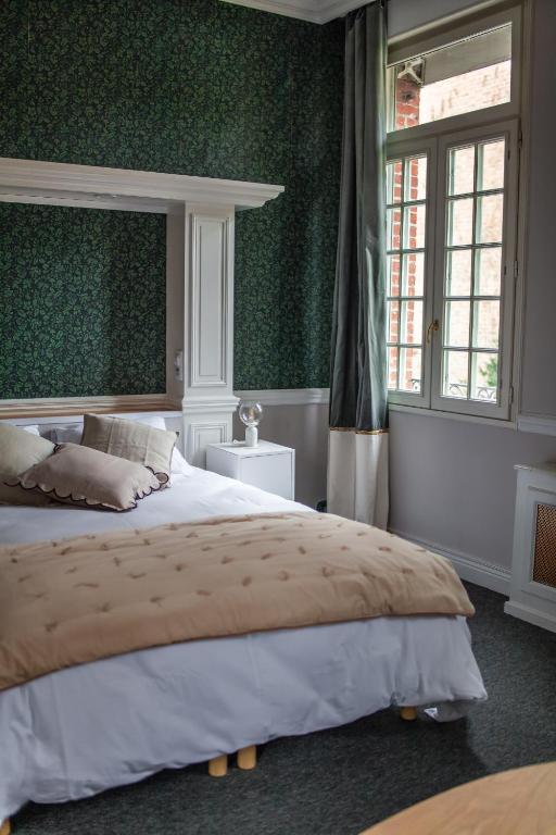 a bedroom with a large bed and green walls at MAISON RENARD in Béthune