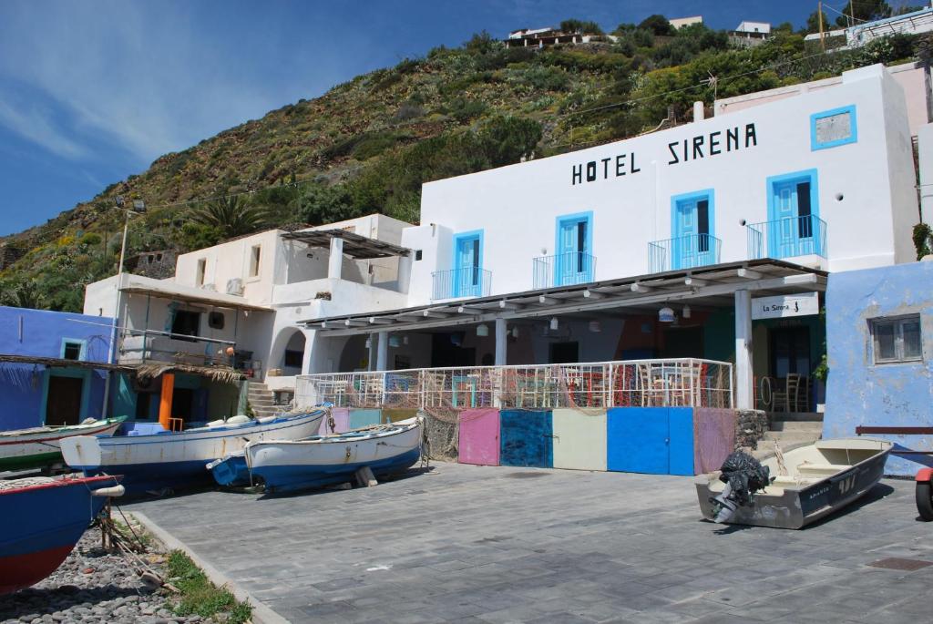 a hotel with boats in front of a building at La Sirena in Filicudi