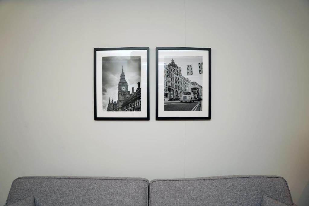 three framed photographs on a wall above a couch at The Londoner Hotel Sliema in Sliema