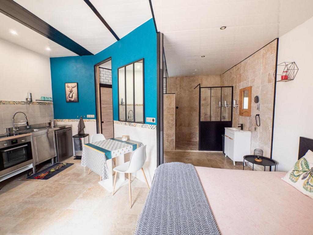 um quarto com uma cama e uma cozinha com uma mesa em L'instant Détente 34 em Saint-Aunès