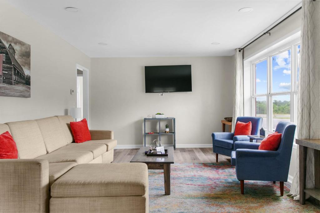 a living room with a couch and chairs and a tv at 10 Min to Downtown-Modern in Magic City-Both Units in Birmingham
