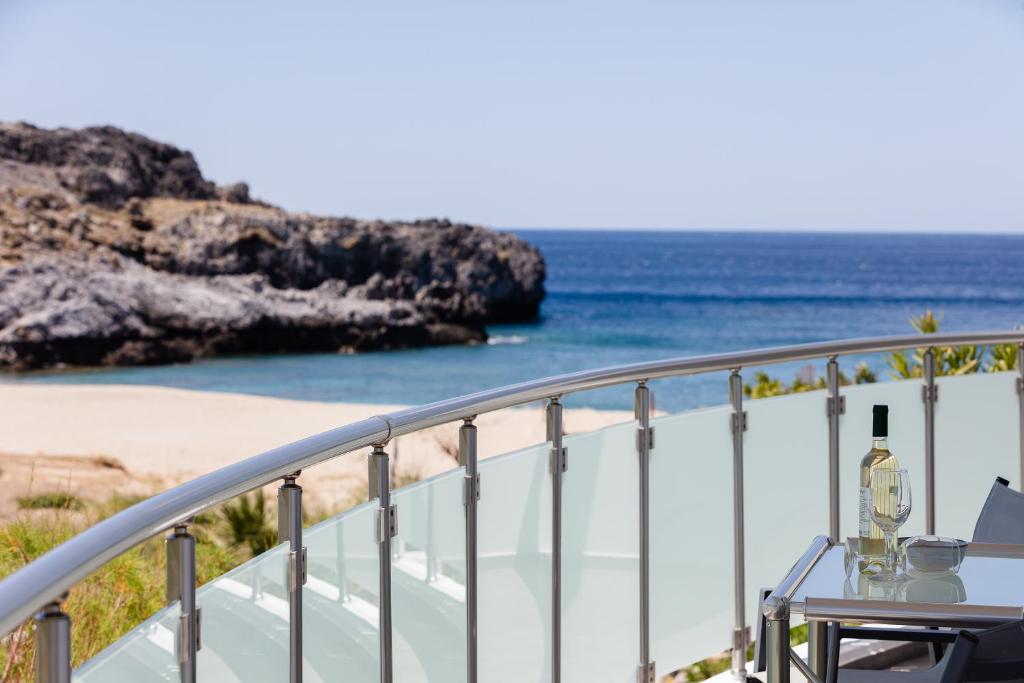 een balkon met uitzicht op het strand bij Nereides - Skinaria Beach Apartment in Damnoni