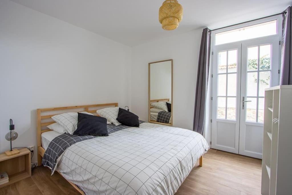 ein Schlafzimmer mit einem Bett und einem großen Fenster in der Unterkunft Appartement avec terrasse et parking, à Meaux in Meaux