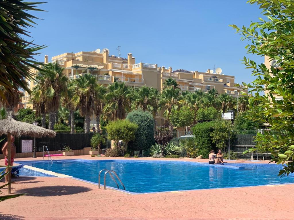 a hotel with a swimming pool in front of a building at Apartamento La Menia - Cabo Roig in Orihuela Costa