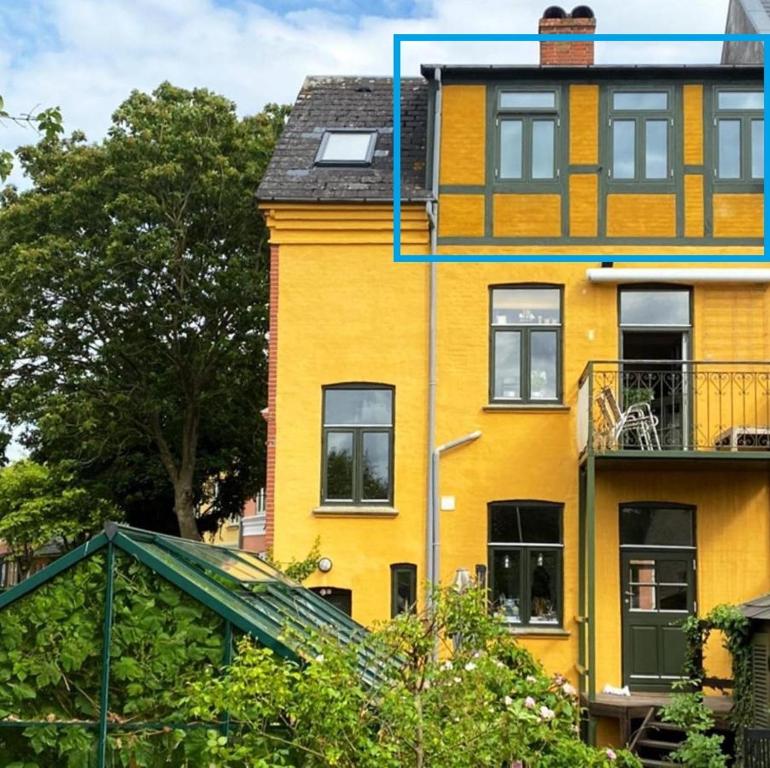 un edificio amarillo con una ventana encima en Townhouse, en Odense