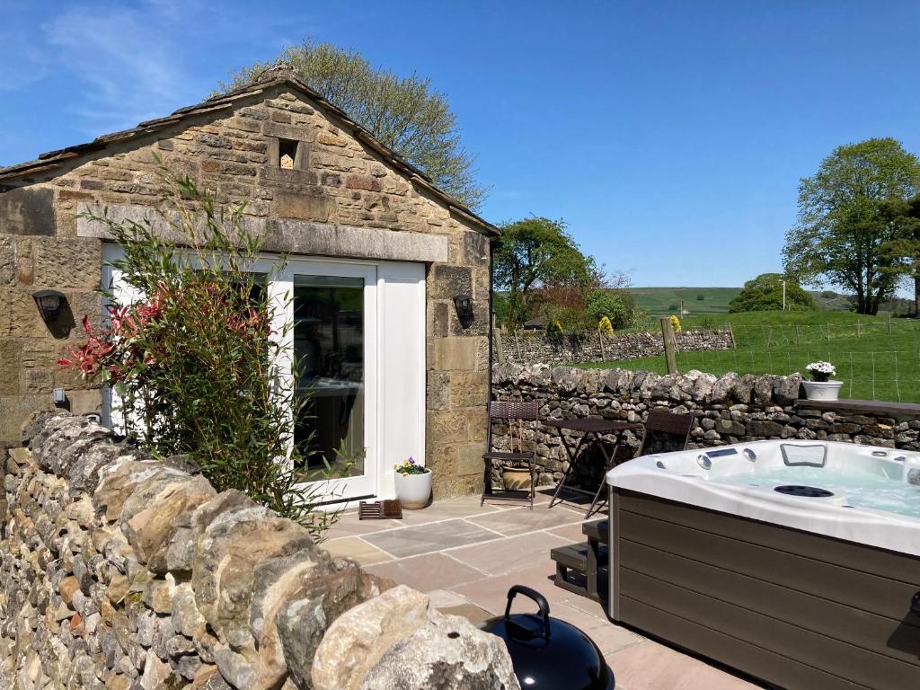 a stone building with a bath tub in a yard at The Folly in Skipton