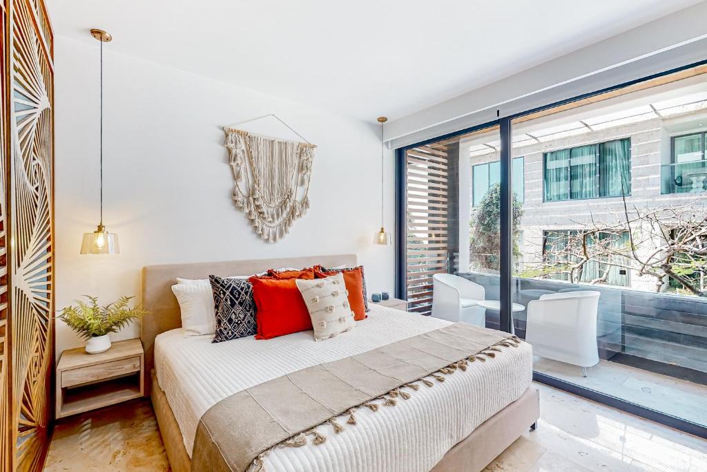 a bedroom with a bed and a large window at Perfect Place 302 in Playa del Carmen