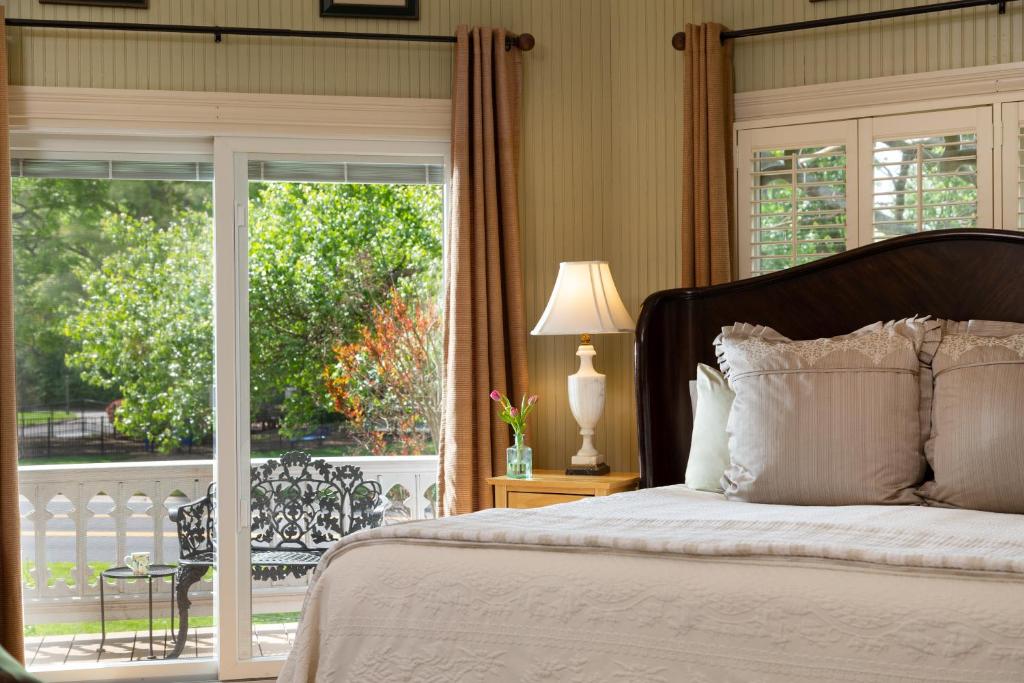 a bedroom with a bed and a sliding glass door at Inn at Woodhaven-In the Heart of the Bourbon Trail-Over 12 Distilleries Nearby in Louisville