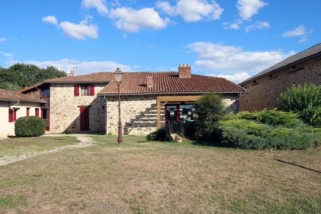 una casa de piedra con un patio delante en Le chambery, en Saint-Junien