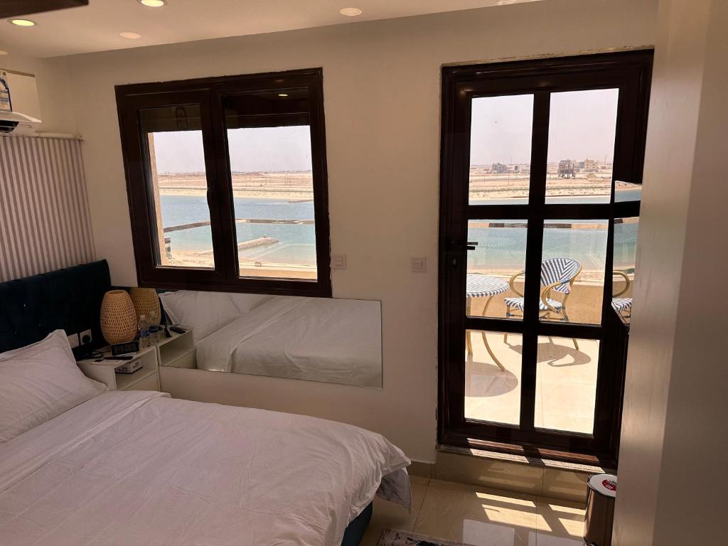 a bedroom with a bed and a view of the ocean at منتجع اووه يامال البحري في الخيران OOh Yaa Mal in Al Khīrān