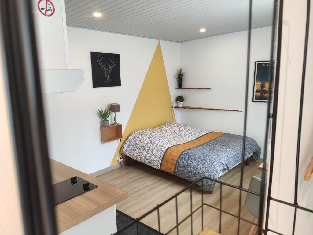een slaapkamer met een bed in een kleine kamer bij Studio ☆ Cité du vin ☆ Stationnement Gratuit dans la rue ☆ Street Park Free in Bordeaux