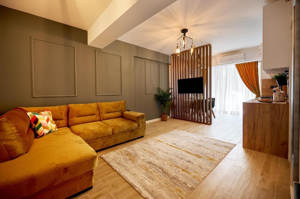 a living room with a couch and a tv at La Mer by Infinity Resort & SPA in Mamaia Sat/Năvodari