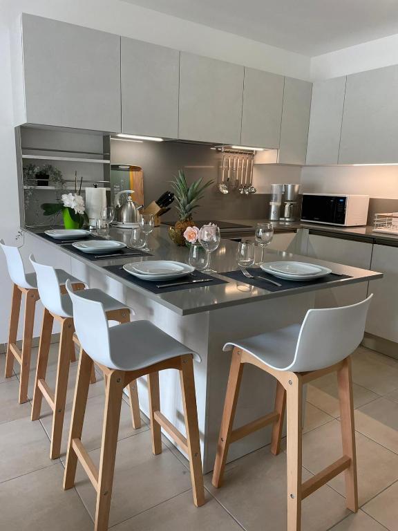 une cuisine avec un grand îlot de cuisine et des chaises dans l'établissement L'écrin des Oliviers, à Grasse