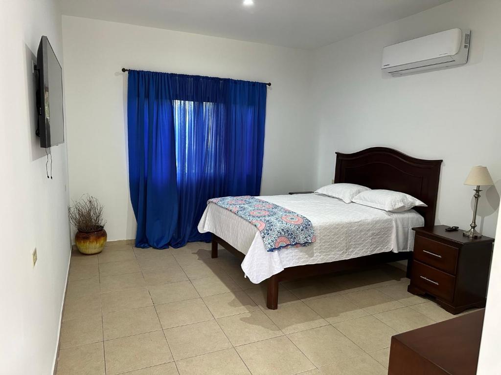 a bedroom with a bed and a blue curtain at Real Paraiso in Juticalpa