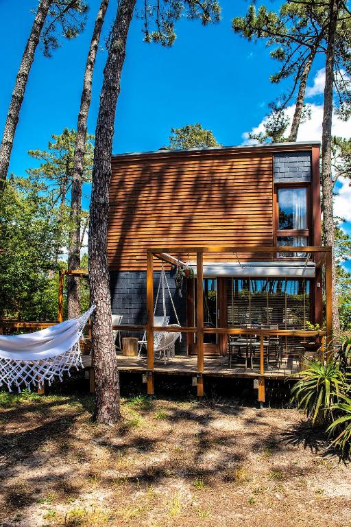 a wooden house with a hammock in a forest at Bungalow B1 em Fão - Ofir by Ana Ferro Rentals in Ofir