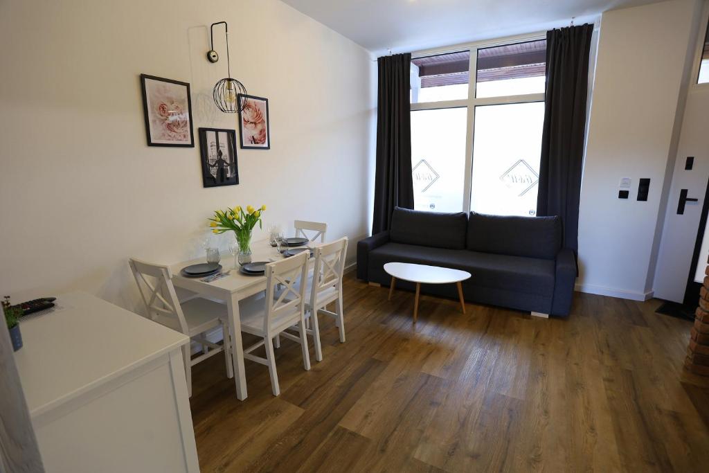a living room with a couch and a table at Apartamenty GREY&WHITE in Ciechocinek