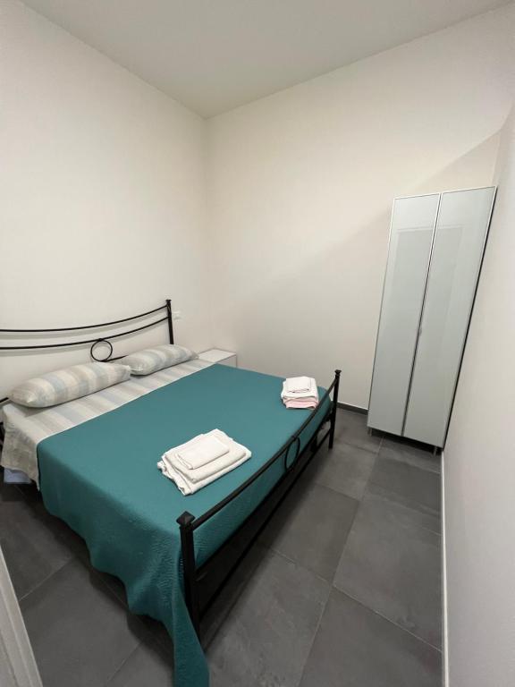 a bedroom with a bed with blue sheets and towels at CasaCalzolari FIERA METEO TECNOPOLO BO in Bologna