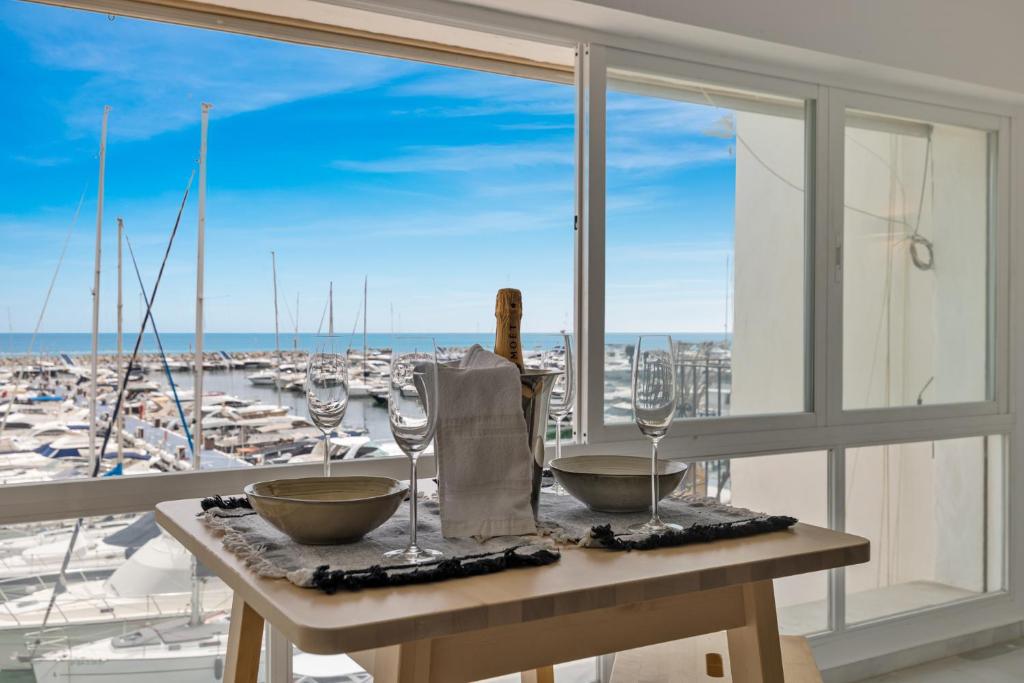 een tafel met wijnglazen en uitzicht op de haven bij luxurious frontline penthouse in puerto banus in Marbella