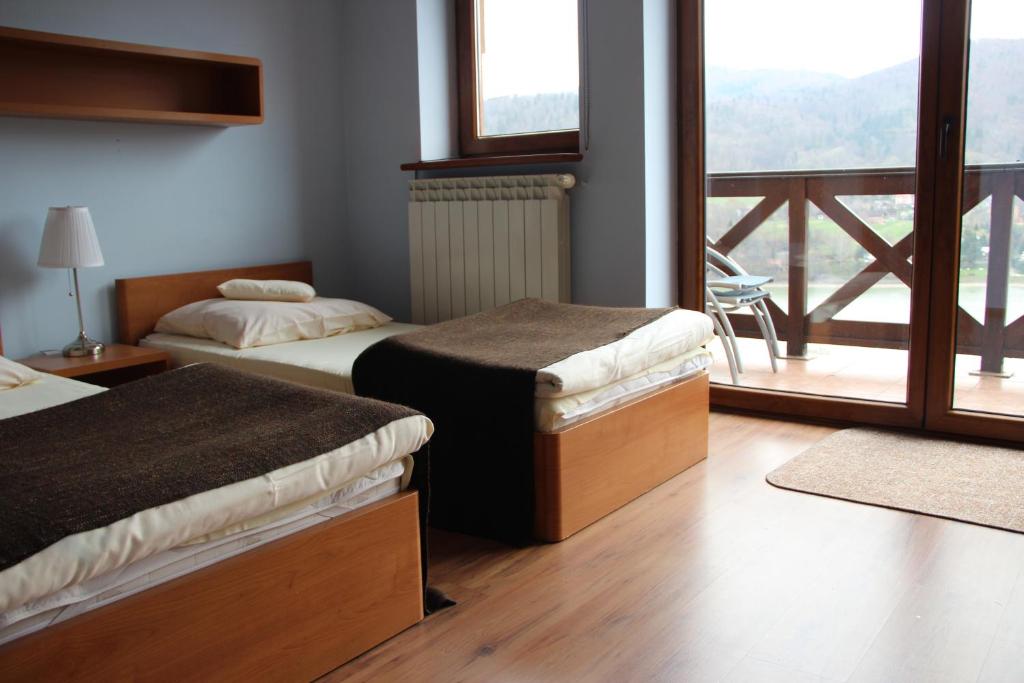 a hotel room with two beds and a balcony at Dom w Górach "TRESNA" in Tresna