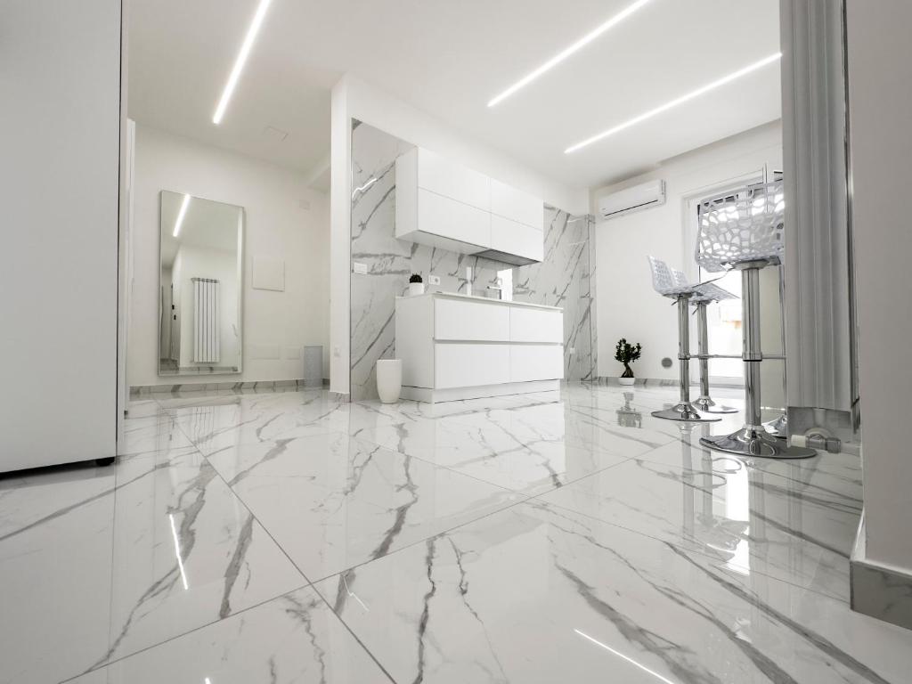 Habitación grande de color blanco con suelo y techo de mármol. en White Elegance Luxury B&B Caserta en Caserta