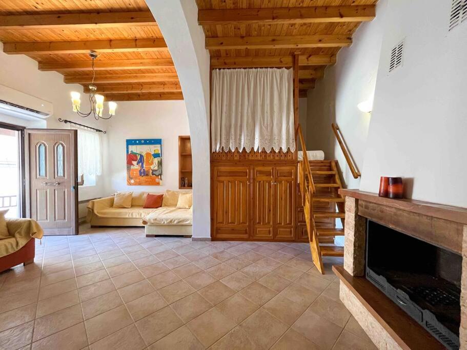 a large living room with a fireplace and a staircase at Kostas Village House in Psinthos