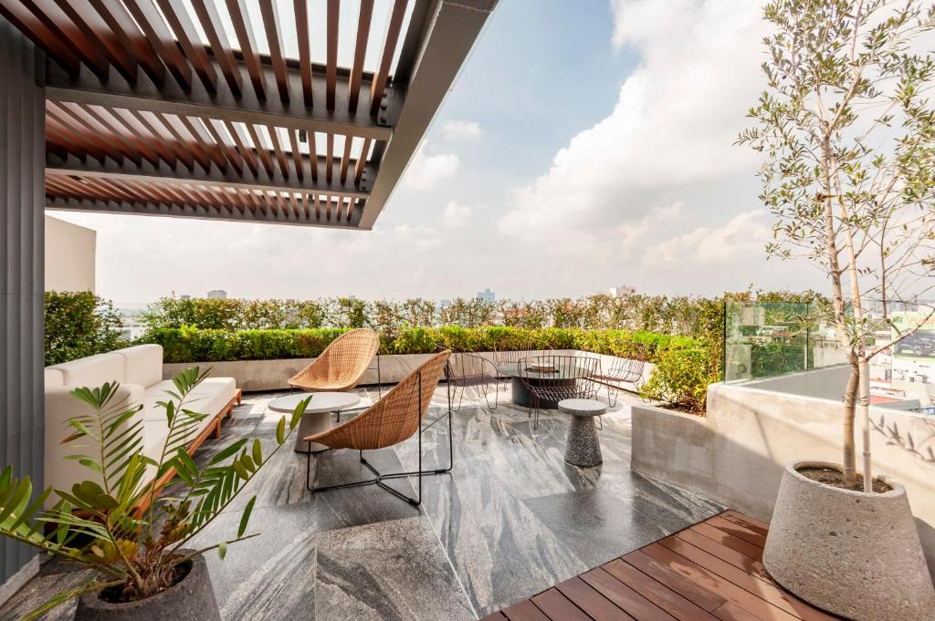 an outdoor patio with a table and chairs and plants at Londres 256 by Wynwood House in Mexico City