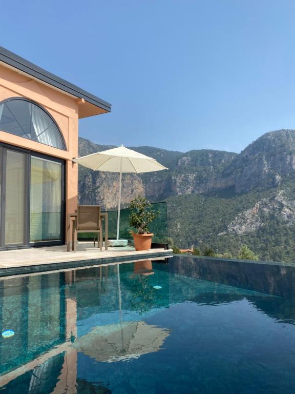 a villa with a swimming pool with mountains in the background at Hestia View in Fethiye