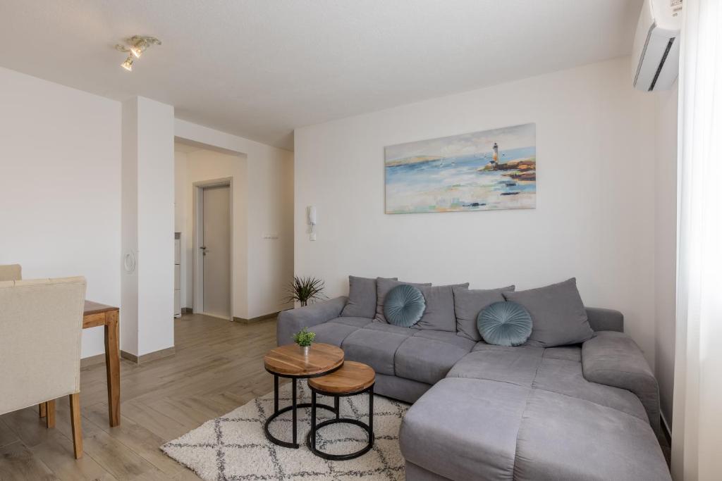 - un salon avec un canapé gris et une table dans l'établissement Apartment Vigo, à Kaštela