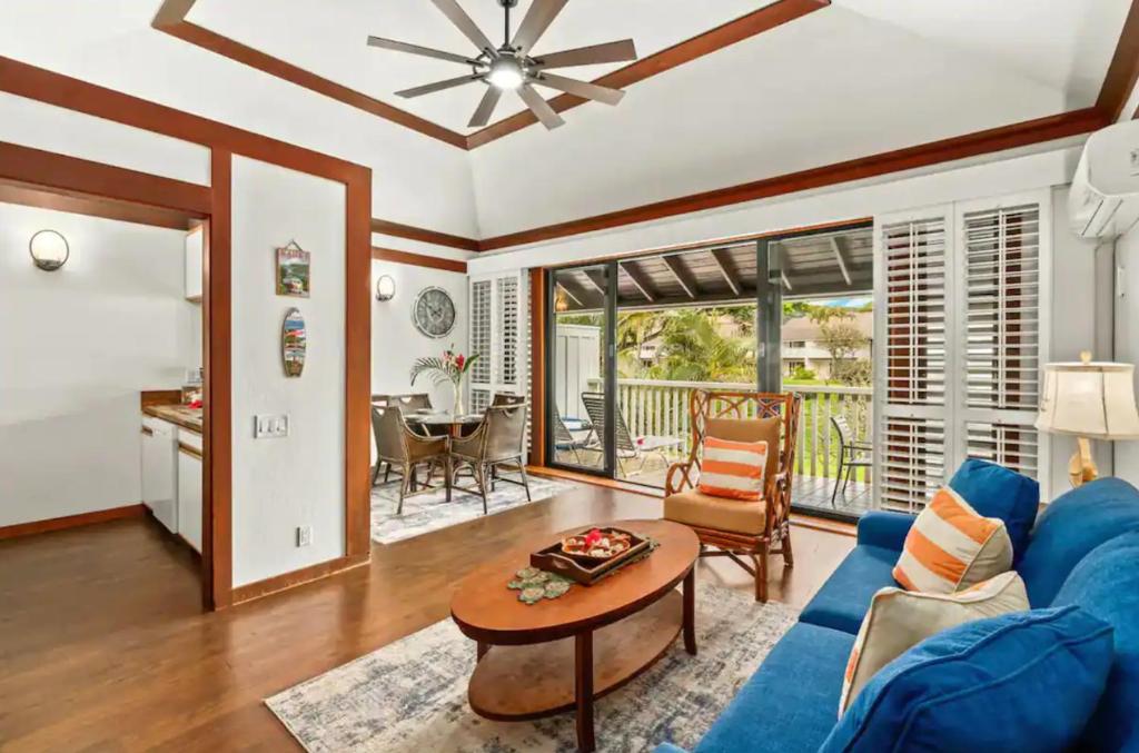 a living room with a blue couch and a table at Kiahuna Plantation Unit 42, Air Conditioning, 2 Minute Walk to Beach in Koloa