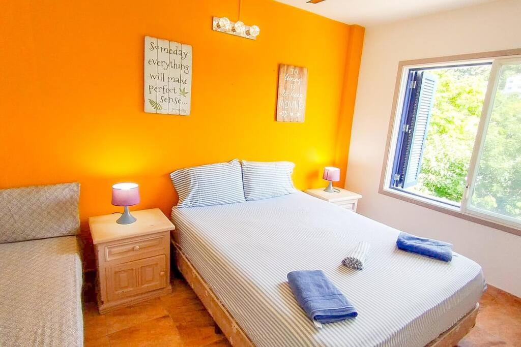 1 dormitorio con paredes de color naranja, 1 cama y ventana en Dep 304a En Casablanca Linda Suite Petfriendly cerca de todo, en Same