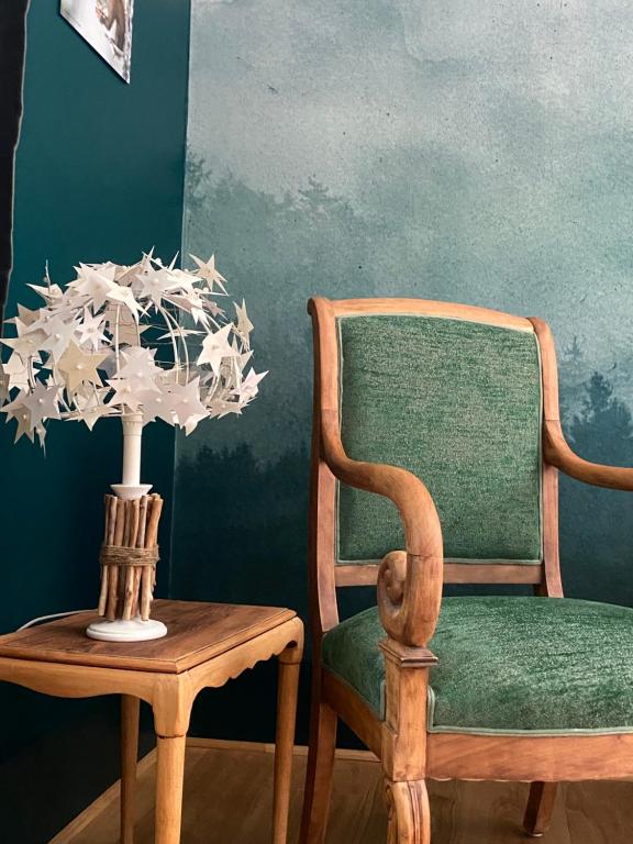 une chaise en bois et une table avec un vase de fleurs sur une table. dans l'établissement La Vieille Eglise, au Hohwald