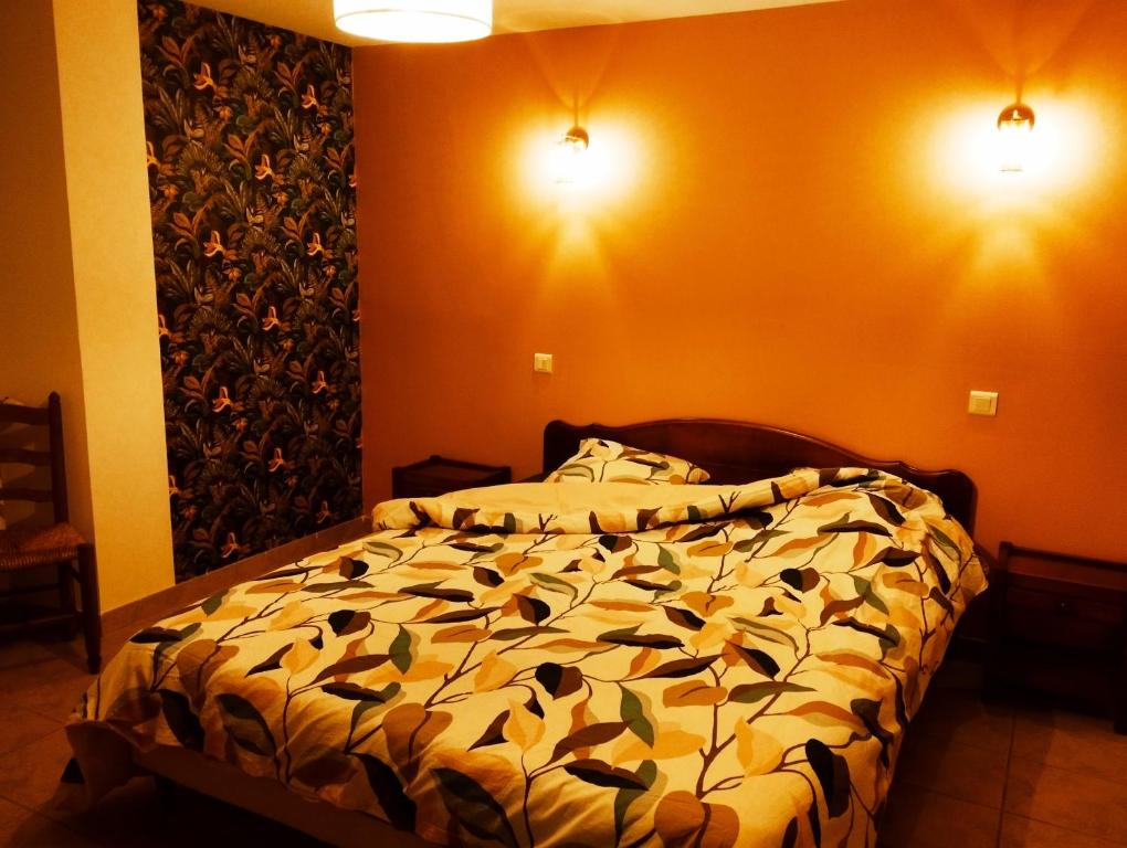 1 dormitorio con 1 cama y 2 luces en la pared en Chambres d'hôtes Microbrasserie & Auberge Ortan, en La Canourgue