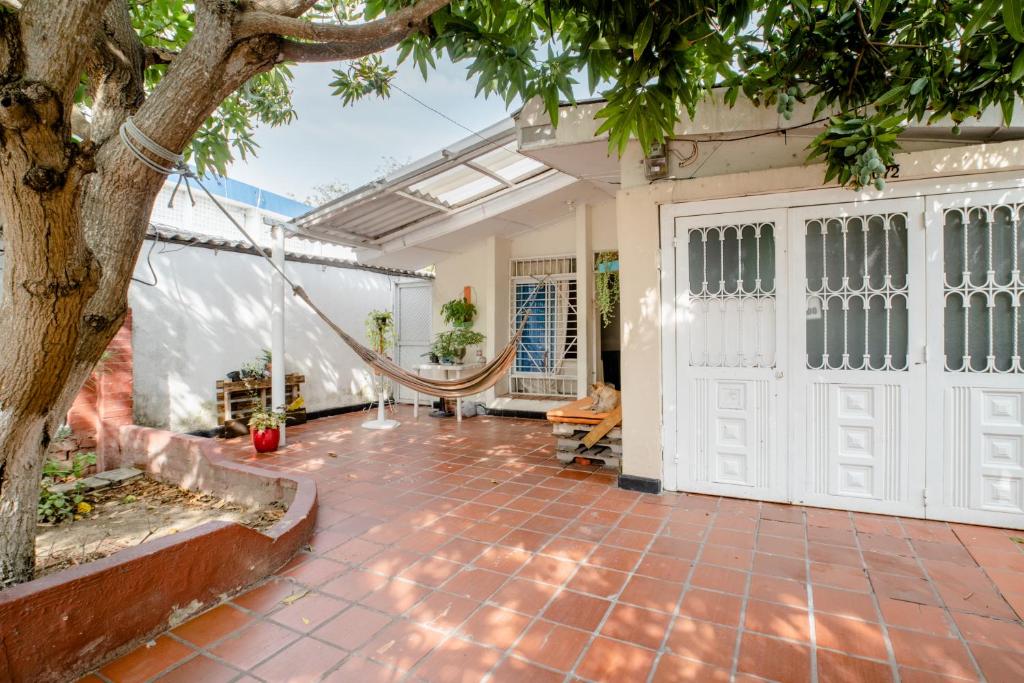 un patio con un árbol y una puerta blanca en HABITACION PRIVADA EN CASA DE MIS PADRES, en Barranquilla