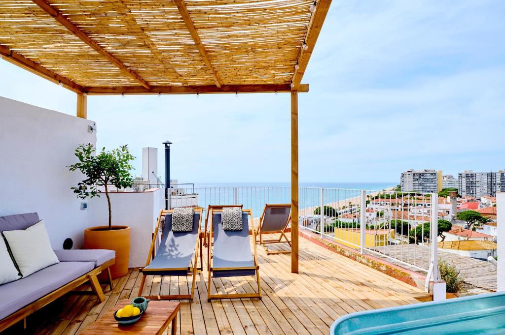 a patio with a couch and chairs on a balcony at El Rancho at the Beach in Blanes