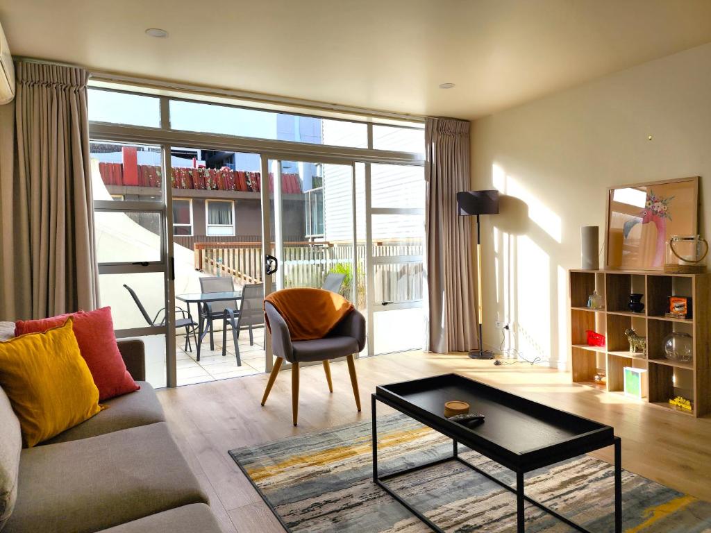 ein Wohnzimmer mit einem Sofa und einem Tisch in der Unterkunft U Suites on Jessie in Wellington