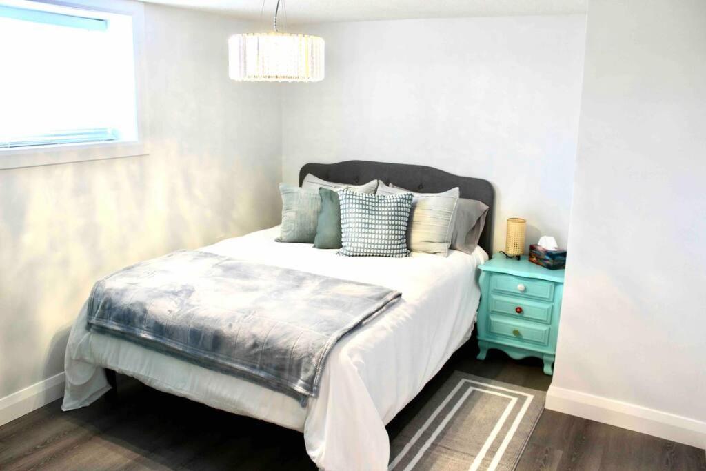 ein Schlafzimmer mit einem Bett und einem blauen Nachttisch in der Unterkunft Hibiscus House in Stratford