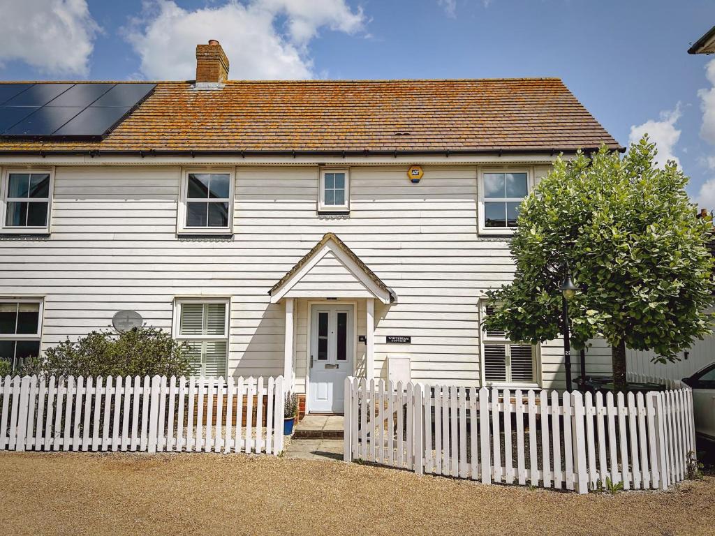 a white house with a white picket fence at Whitebeam in Camber