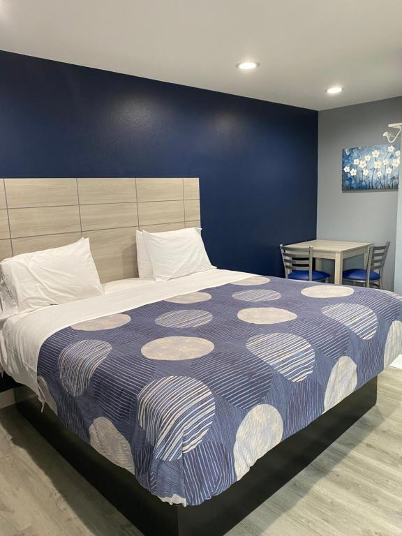 1 dormitorio con 1 cama grande y pared azul en Dunmore Inn en Dunmore