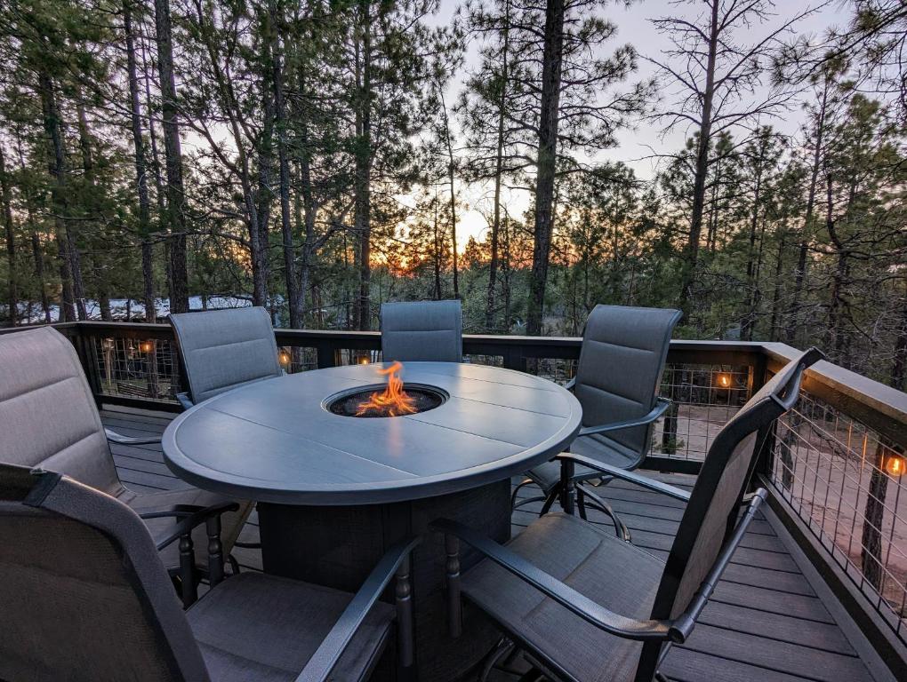 a table and chairs on a deck with a fire pit at Pinetop Getaway w Sunset Deck & Fire Pit Table in Pinetop-Lakeside