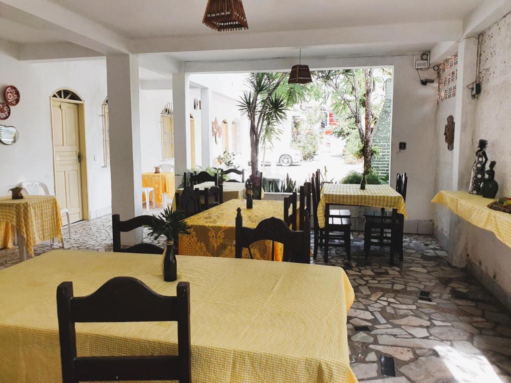 een restaurant met tafels en stoelen met geel tafelkleed bij Pousada Sonho Meu in Porto Seguro