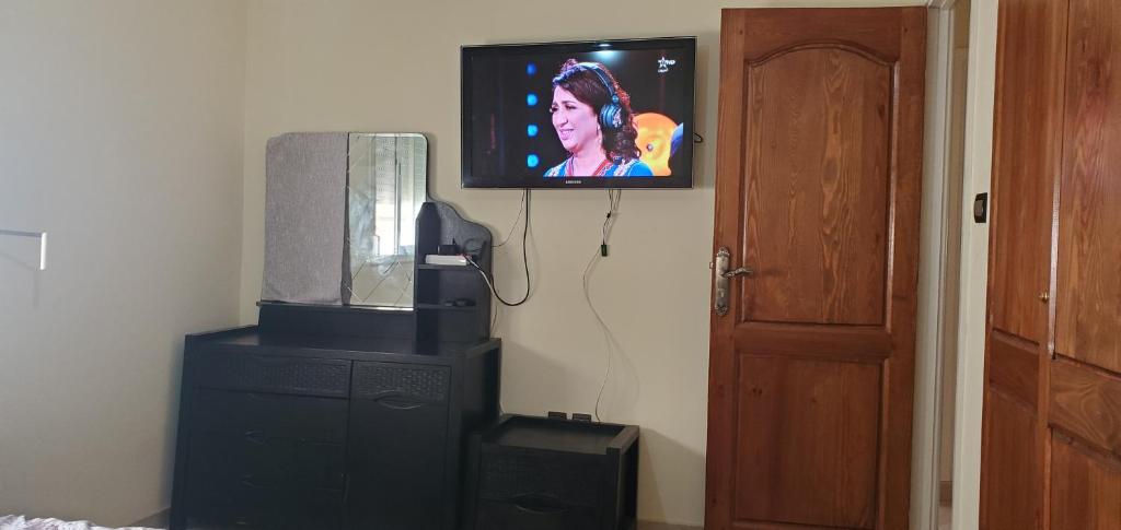 a flat screen tv on a wall next to a dresser at appartement meublé avec wifi in Safi