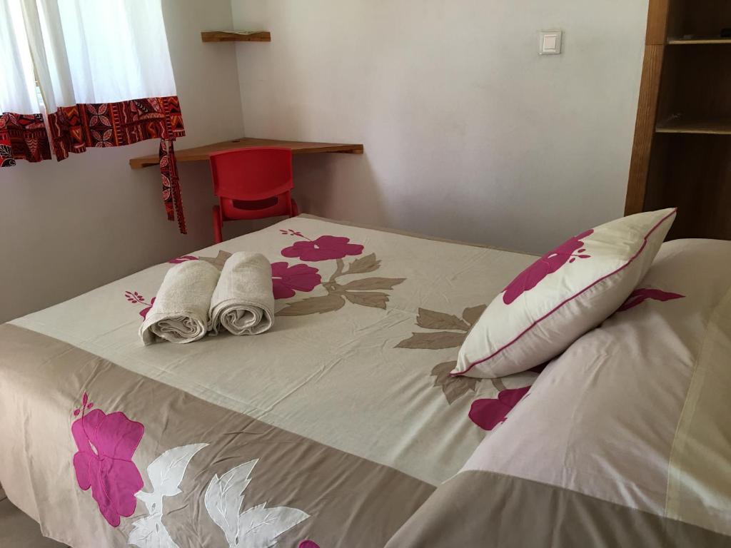 a bed with towels and pillows on top of it at Pension Te Aroha - Te Rai in Maatea