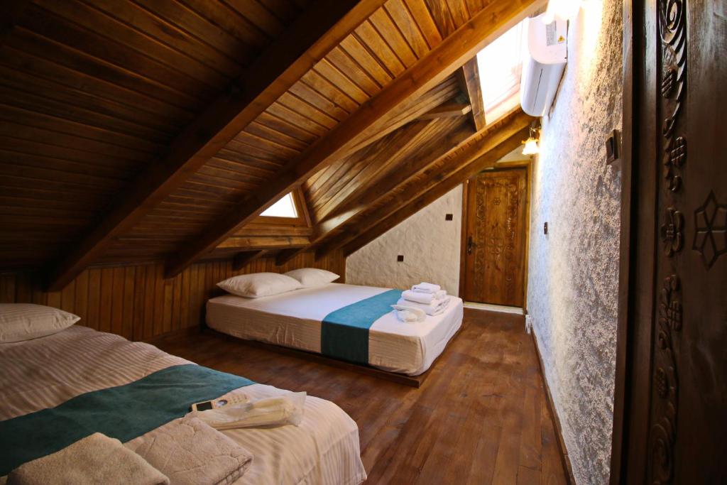 a bedroom with two beds in a wooden house at Homeros Butik Otel in Dikili