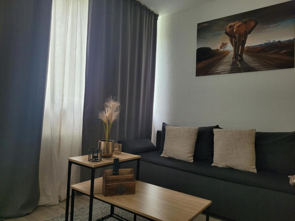 ein Wohnzimmer mit einem blauen Sofa und einem Tisch in der Unterkunft Stilvolle Wohnung in Wuppertal inkl. Kaffee & Tee in Wuppertal